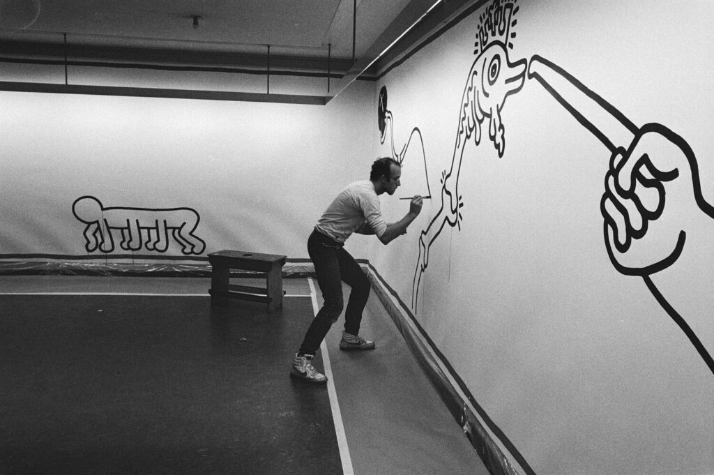 Haring painting a mural at the Stedelijk Museum in Amsterdam, Netherlands, 1986