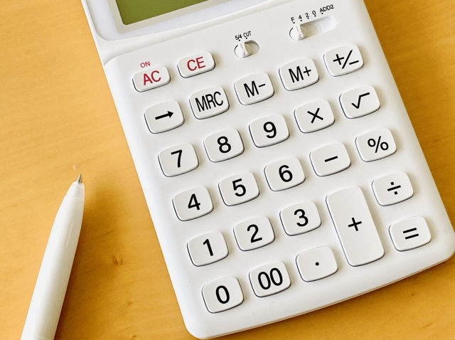 白い電卓と白いボールペン