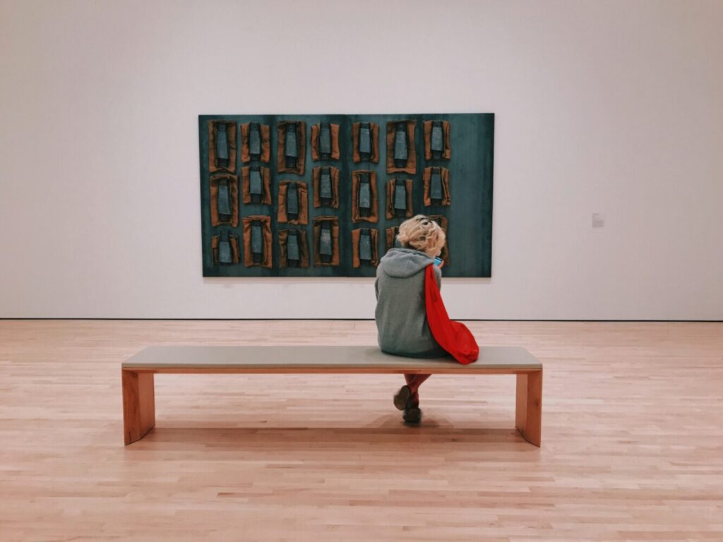 絵の前のベンチに座っている人